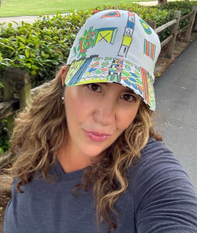 Camila wearing a colorful illustrated cap